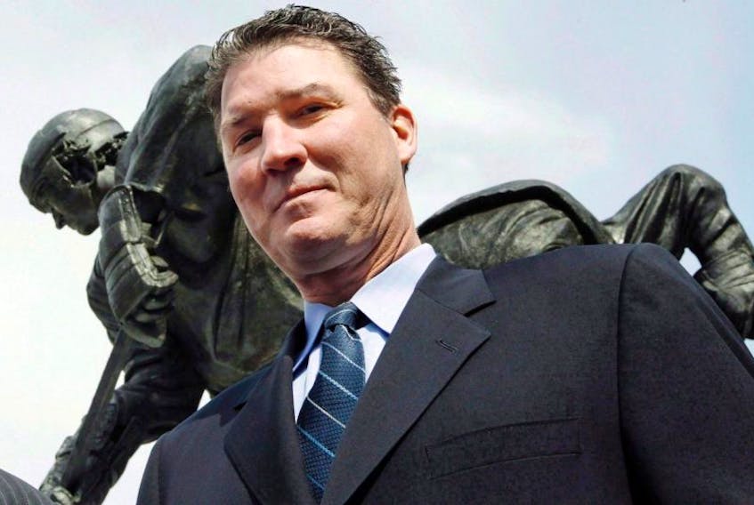 Pittsburgh Penguins Hall of Fame center Mario Lemieux stands near the statue of him at left that was unveiled outside the NHL hockey team's arena on Wednesday, March 7, 2012, in Pittsburgh. The Order of Hockey in Canada is welcoming Hall of Fame forward Lemieux and women's hockey star Geraldine Heaney into its ranks.