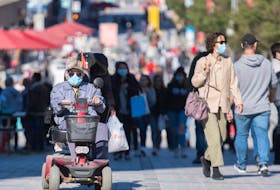 People wear face masks on a street in Montreal, Sunday, Sept. 20, 2020, as the COVID-19 pandemic continues in Canada and around the world.