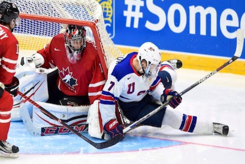The net tips over Canada's Mason McDonald as the United States' Matthew Tkachuk (7) gets caught up during third period preliminary hockey action at the IIHF World Junior Championship in Helsinki, Finland, on Saturday, Dec. 26, 2015.