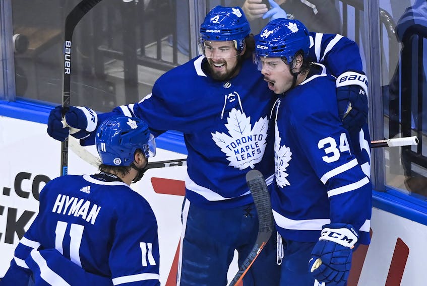 Maple Leafs centre Auston Matthews (34) celebrates his goal with teammates Justin Holl (3) and Zach Hyman after scoring against the Columbus Blue Jackets in the second period of their NHL Eastern Conference play-in game on Tuesday.