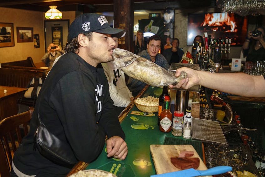 Maple Leafs centre Auston Matthews gets into the spirit and kisses a cod at a George St. bar called Christian’s in St. John's, NL. (Toronto Maple Leafs/Twitter)
