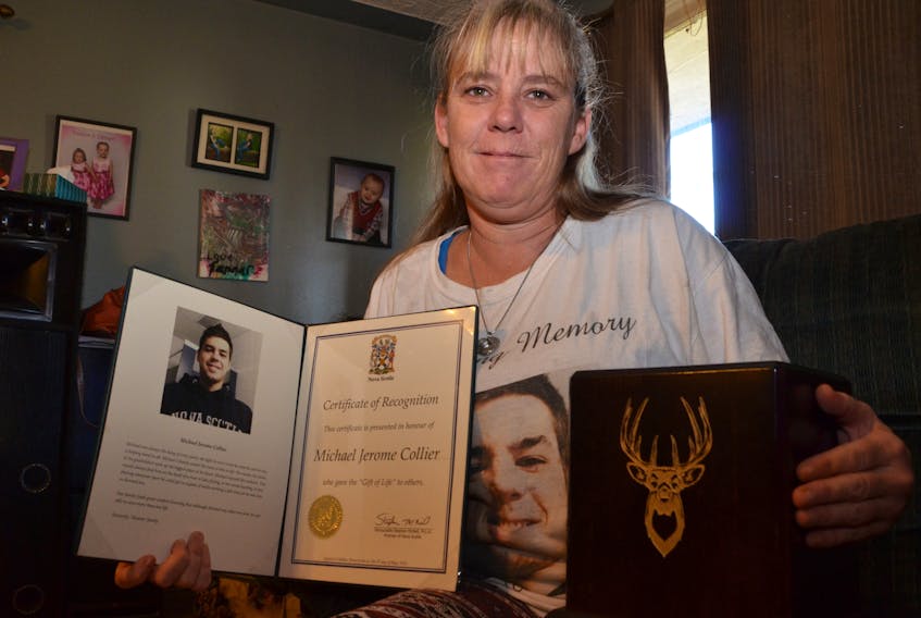 Donna Nugent holds her son's ashes and a certificate of appreciate for the organs that Michael Collier gave so others would benefit from his death.