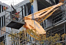 A work crew using two hydraulic cranes and a team of welders in a suspended cage remove two long pieces of the neck, or front jib, that dangled from the roof of an apartment building under construction just off Spring Garden Road on Thanksgiving weekend. The crane was downed by hurricane Dorian on Sept. 7.