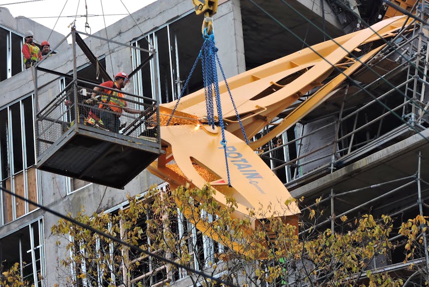 A work crew using two hydraulic cranes and a team of welders in a suspended cage remove two long pieces of the neck, or front jib, that dangled from the roof of an apartment building under construction just off Spring Garden Road on Thanksgiving weekend. The crane was downed by hurricane Dorian on Sept. 7.
