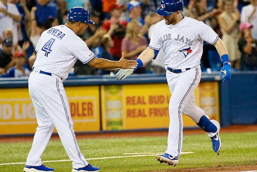 Toronto Blue Jays right fielder Billy McKinney celebrates with third base coach Luis Rivera (left) after hitting a home run during the sixth inning against the Texas Rangers at Rogers Centre. 