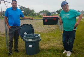 Membertou health and safety officer Peter Stevens, left, with Carey Gould, maintenance. Disinfectant tool kits have been installed at the Membertou playgrounds. Oscar Baker III • Cape Breton Post