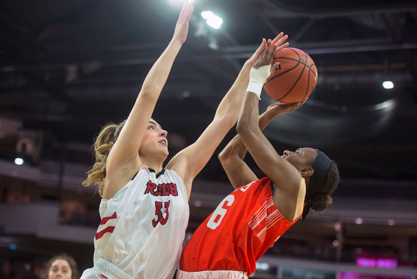 Jolianne Guay of the UNB Reds blocks a shot from Cape Breton Capers guard Monique Calliste during Friday afternoon’s AUS women's basketball championships quarter-final at the Scotiabank Centre. (Ryan Taplin/The Chronicle Herald)