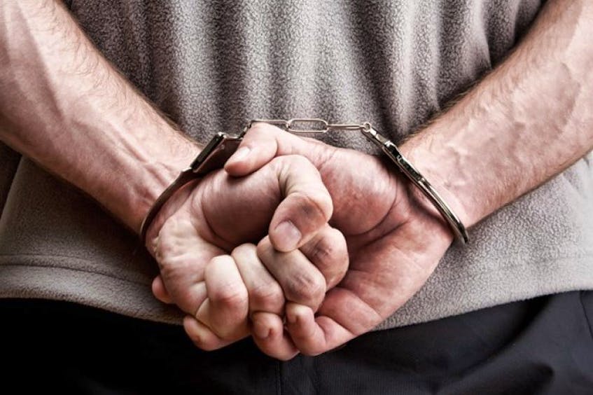 A man is shown in handcuffs.