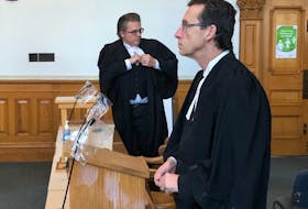 Prosecutor Mike Murray (foreground) watches Justice Vikas Khaladkar leave the courtroom after sentencing a MUN student for attempted murder in Newfoundland and Labrador Supreme Court in St. John's Thursday, as defence lawyer Mark Gruchy looks toward his client in the prisoner's dock.