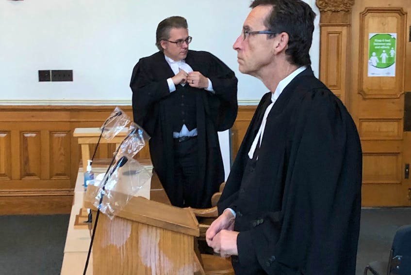 Prosecutor Mike Murray (foreground) watches Justice Vikas Khaladkar leave the courtroom after sentencing a MUN student for attempted murder in Newfoundland and Labrador Supreme Court in St. John's Thursday, as defence lawyer Mark Gruchy looks toward his client in the prisoner's dock.