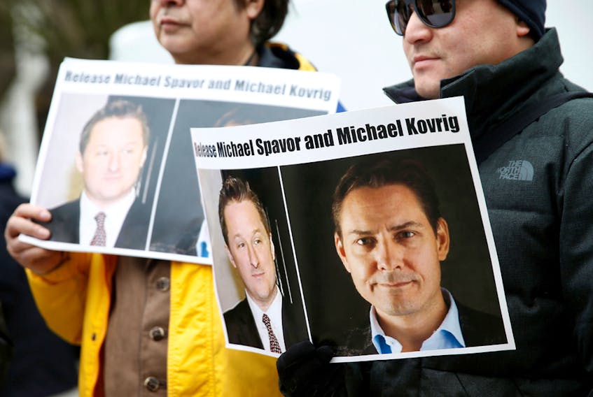 People hold signs calling for China to release Canadian detainees Michael Spavor and Michael Kovrig during an extradition hearing for Huawei Technologies Chief Financial Officer Meng Wanzhou at the B.C. Supreme Court in Vancouver on March 6, 2019.  