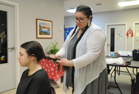 Michelle Bennett makes a rope-style braid on her daughter Eva Pike’s hair at the People of the Dawn Indigenous Friendship Centre in Stephenville. FRANK GALE/THE WESTERN STAR