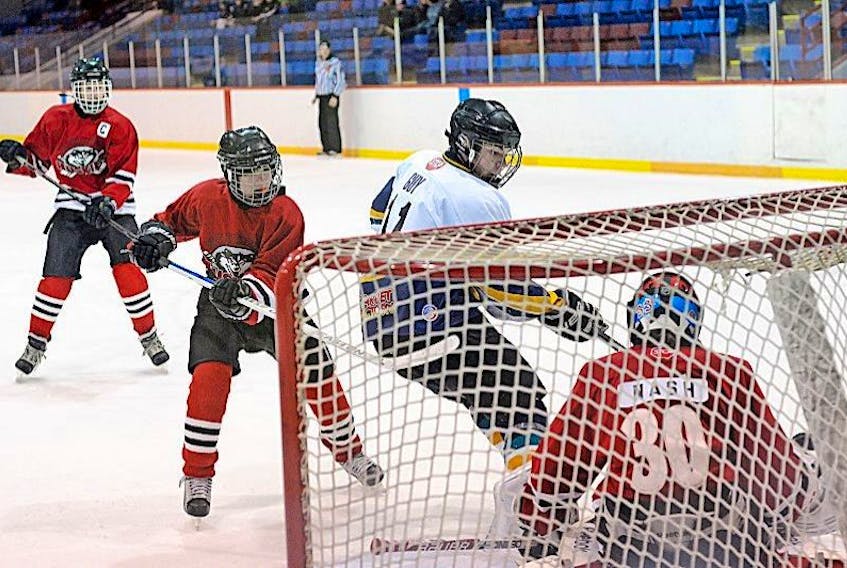In this 2013 file photo, Dylan Guy, 11, of the St. John's Ice Breakers, is foiled on a scoring chance by goaltender David Nash, 30, of the Northern Huskies from Labrador. Looking on from left are Huskies Matthew Grouchy and Dalton Saunders. Hockey Newfoundland and Labrador are exploring the possibility of amalgamating a number of associations in urban and rural areas following a report which suggested there could be great efficiency at the minor hockey level.