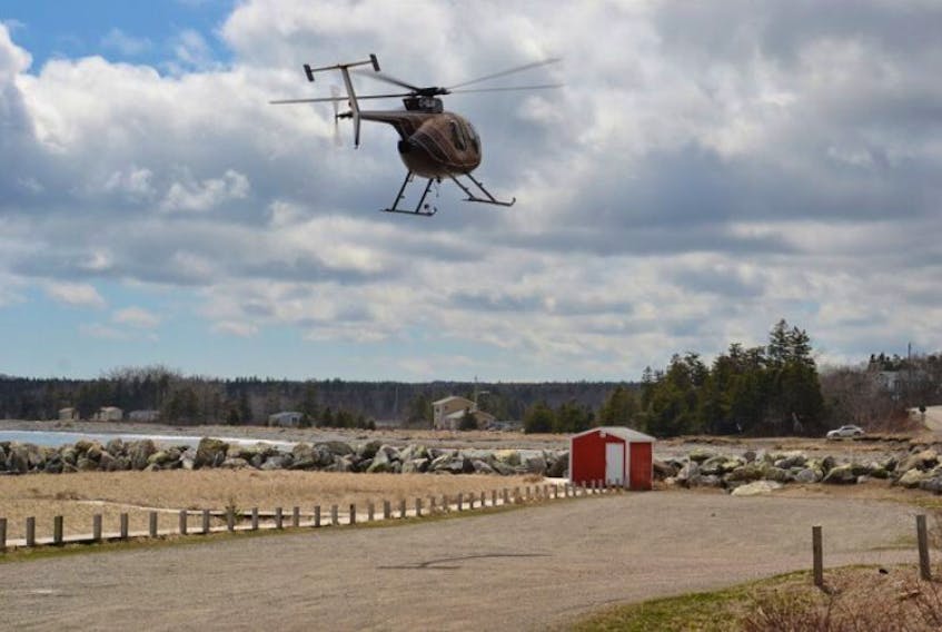 A Department of Natural Resources helicopter takes off from Mira Gut beach Saturday afternoon to begin a search of the nearby water and wooded area.