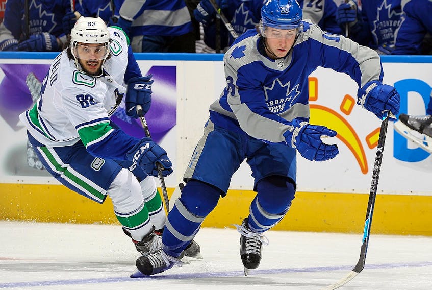 Jalen Chatfield of the Vancouver Canucks chases after Mitchell Marner of the Toronto Maple Leafs at Scotiabank Arena on February 6, 2021 in Toronto. 