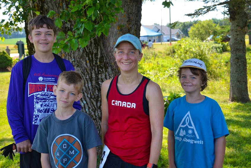 Dr. Helga Reisch-MacNeill of Kensington poses with sons Matthew, back left; Thomas, front left, and Sam, right, following the 46th annual Harvest Festival 25-Kilometre Road Race on Saturday morning. Reisch-MacNeill had a time of one hour 53 minutes 20 seconds (1:53:20) to claim top female honours and finish fifth overall in the 43-runner field.