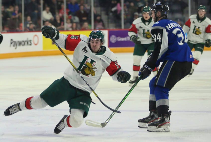 Halifax Mooseheads forward Jordan McKenna is tripped up by Saint John Sea Dogs forward Anderson MacDonald during Sunday's QMJHL game at the Scotiabank Centre. (TIM KROCHAK/Chronicle Herald)