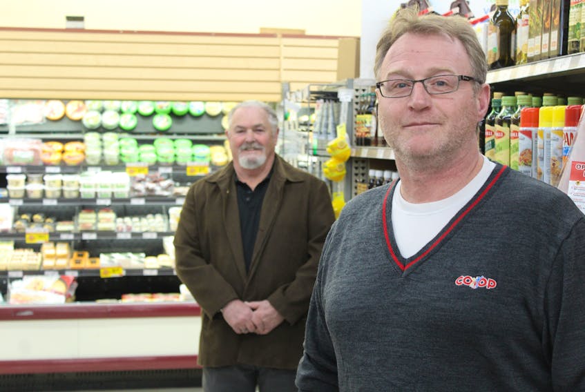 Greg Dunn, right, stands in an aisle of the store he manages, Morell Consumers Co-op, alongside board president Garry Doyle on April 15.