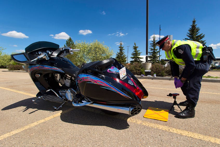 In this file photo, police constable Trevor Henderson of the Edmonton Police Service's traffic section tests the noise level of a motorcycle. — Greg Southam 