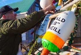 Murray Harbour councillor Gary MacKay adjusts one of the buoys hanging on the community's lobster trap Christmas tree.