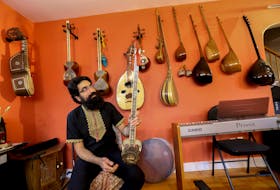 FOR COOKE STORY:
Musician, Mohammad Sahraei, looks over a python skin strung instrument in his Halifax home Thursday January 7, 2021

TIM KROCHAK PHOTO 