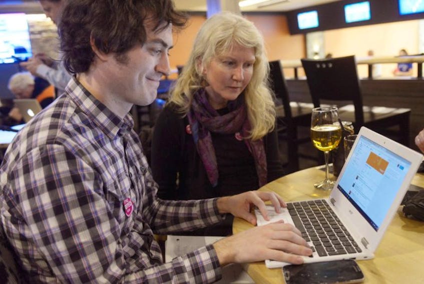 Mark Greenan, left, and Sarah Saunders, take a look at the results coming in online for the electoral reform plebiscite. Mixed member proportional representation was the most popular choice in P.E.I.’s plebiscite on electoral reform.