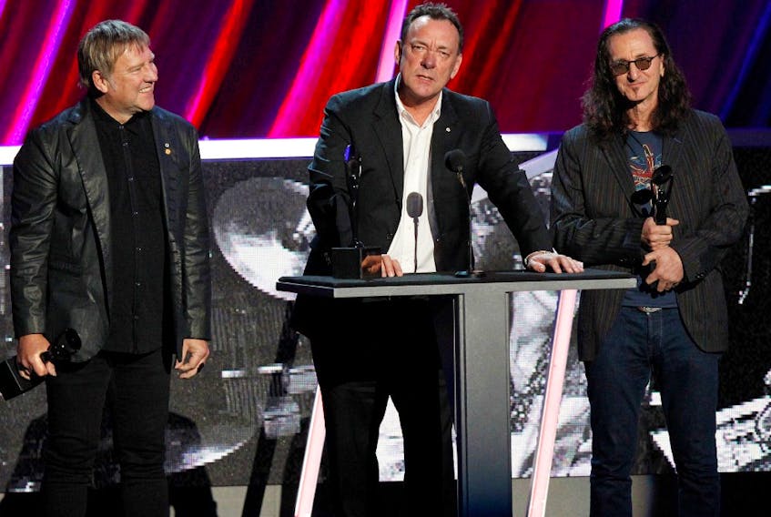  Alex Lifeson (L), Neil Peart and Geddy Lee (R) of Rush are inducted at the 2013 Rock and Roll Hall of Fame induction ceremony in Los Angeles April 18, 2013.