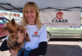 Karla Shalley holds Piper at the P.E.I. CARES booth at the Charlottetown Farmers' Market on Saturday, Aug. 29. Shalley rescued Piper, who is missing her bottom jaw, from Texas.