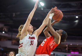 Jolianne Guay of the UNB Reds blocks a shot from Cape Breton Capers guard Monique Calliste during an AUS women's basketball championships quarter-final at the Scotiabank Centre. (Ryan Taplin/The Chronicle Herald)
