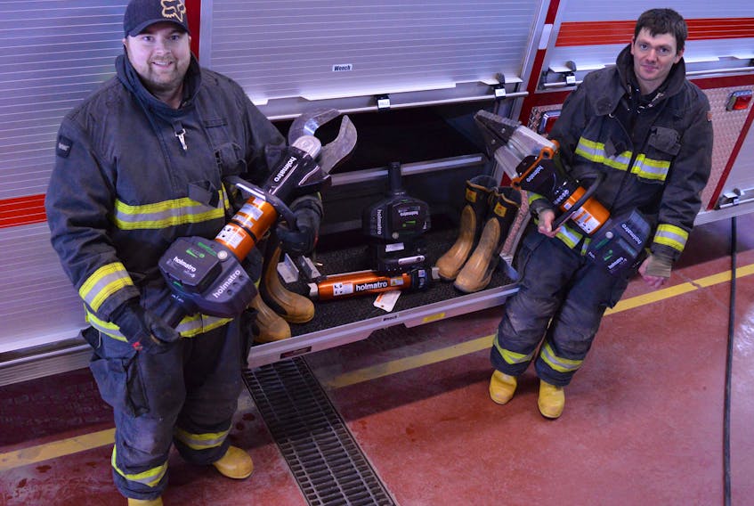 Wellington Fire Department safety officer Chris Gallant, left, and secretary treasurer Jason Maddix lift the department's new Jaws of Life equipment. Alison Jenkins/Journal Pioneer