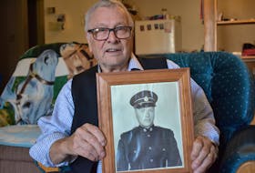 Gerald Keddy of New Minas holds up a photo of him from the 1950s, when his service in the Royal Canadian Army saw him dispatched overseas following the Second World War. 