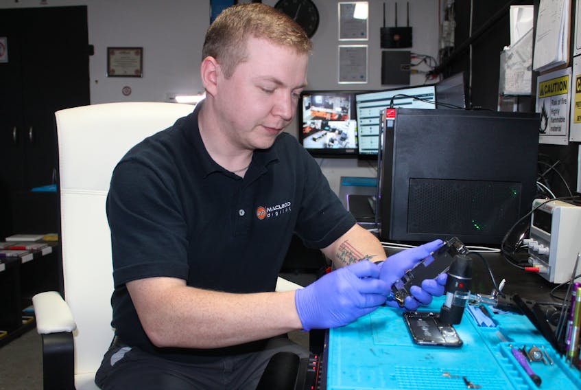 Kyle MacLeod, owner of MacLeod Digital, repairs a cellphone at his office on Veniot Avenue in New Waterford. The 28-year-old began his business in 2018 and has more than 650 clients, including telecommunication companies. JEREMY FRASER/CAPE BRETON POST