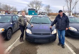 Elizabeth Doyle, left, and Chuck Ogley stand next to some of their District 11 Taxi vehicles.  The couple have decided to start delivering grocery orders for free to people who want to stay home during the COVID-19 outbreak. Contributed/ Chuck Ogley