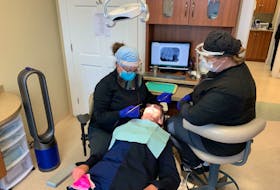 Dr. Michelle Zwicker (left) and dental assistant Glenda Doyle demonstrate what a patient can expect while in the dentist’s chair at Zwicker’s Bay Roberts practice.