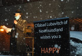 Via FM reception, Chabad Newfoundland Rabbi Chanan Chernitsky speaks to the folks in their cars at the parking lot of the Viking Buildiing on Crosbie Road in St. John’s on the evening of Dec. 13 for the lighting of the Menorah to begin the Jewish holiday of Hanukkah. Joe Gibbons/The Telegram
