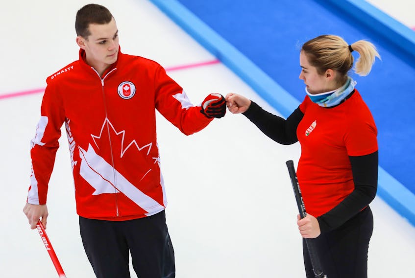 Nathan Young of Torbay and Laura Nagy of Hungary fist bump during their first game in the mixed doubles curling competition at the 2020 World Youth Olympics in Lausanne, Switz. — WCF via Curling Canada