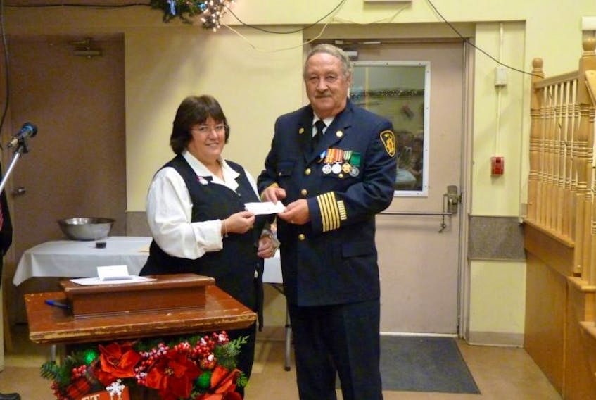 <p>New Minas Fire Department Auxiliary president Laura Huntley presents New Minas fire chief James Redmond with a $55,000 donation to the fire department. – Submitted</p>