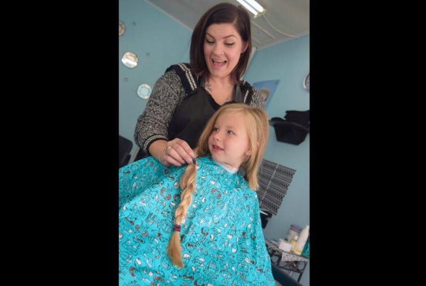 Five-year-old Savannah Cholmondeley, getting her hair cut by Nicole Mason at Stellar Locks Hair Salon, on Saturday. Cholmondeley donated her hair to help manufacture wigs for cancer patients. 