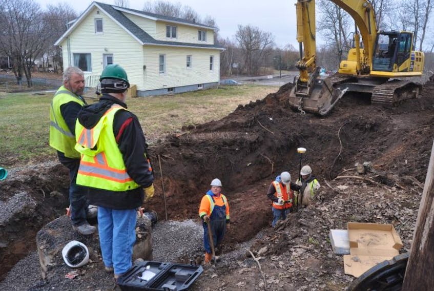 A construction crew works Monday on extending the water and sewer lines to the new wing of the Nova Scotia Community College campus in Stellarton.