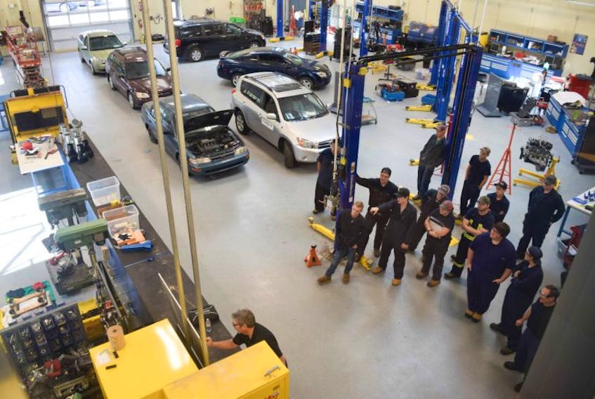 Automotive students listen as instructor Damian Hall teaches them in their new shop at the NSCC Campus in Stellarton.