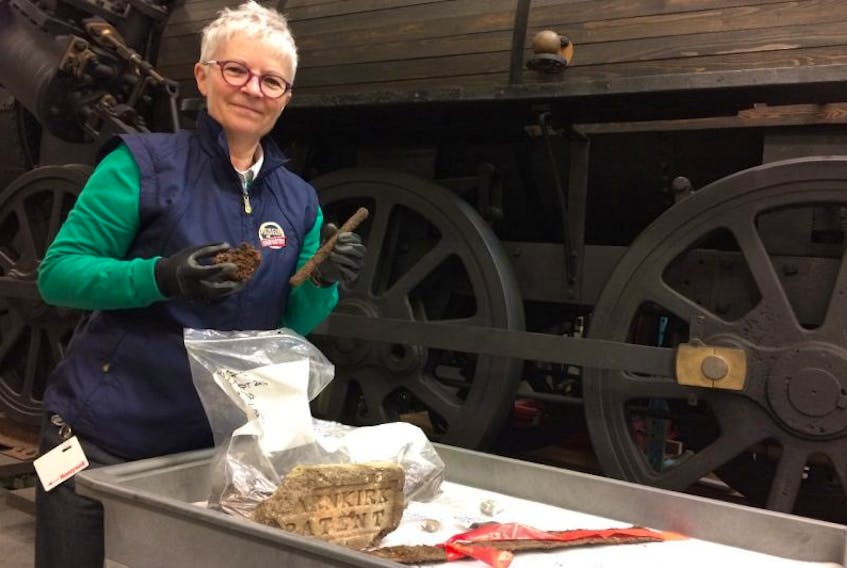 Debra McNabb of the Museum of Industry stands with artifacts retrieved from a dig this past fall at the museum’s foundry site. An artifact cleaning workshop will be held this Saturday at the museum. 