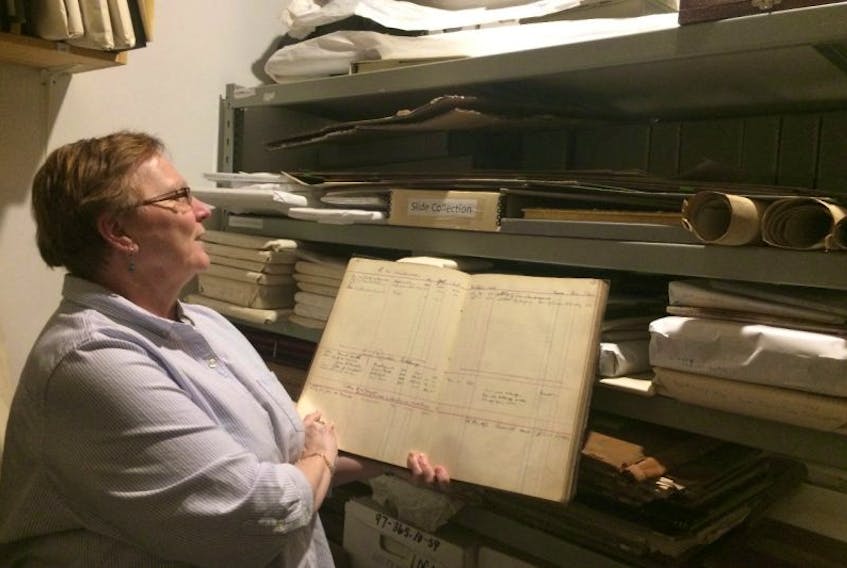 Judy Cormier, a volunteer with the McCulloch Heritage Centre, looks over an old ledger in storage at the centre. Museums are continuing to accept historical pieces, but storage is a concern. A process is followed by all Nova Scotia Museums as to what can be accepted.