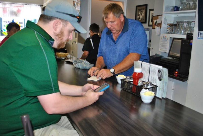 John Stewart takes an order from customer Andrew MacKinnon of New Glasgow at Sharon’s Place Family Restaurant on Monday. Businesses in Pictou benefited from the tall ships visit to the town this weekend.

