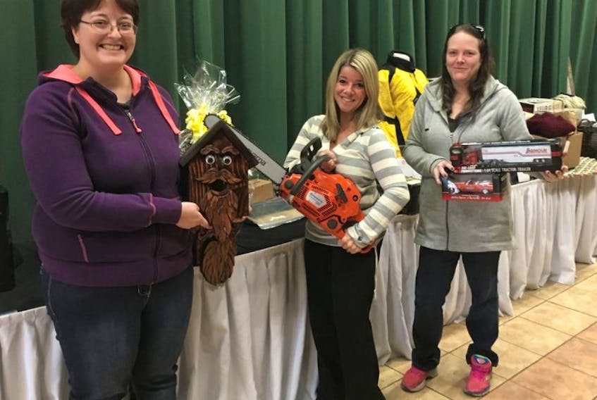Pictured holding some of the items up for the silent auction are: Megan Hartling, Karen Corbin Hughes and Jackey MacDonald. 