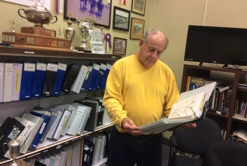 Barry Trenholm, curator with the Pictou County Sports Hall of Fame, looks over paper copies of archives at the New Glasgow museum.  The sports hall had its computer files corrupted by a virus that won’t allow access to them unless a price is paid. 