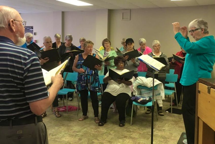 The Trinitarians, under the direction of Monica George Punke, practice in preparation for their upcoming concert, Songs We Love – A Celebration of Canada.