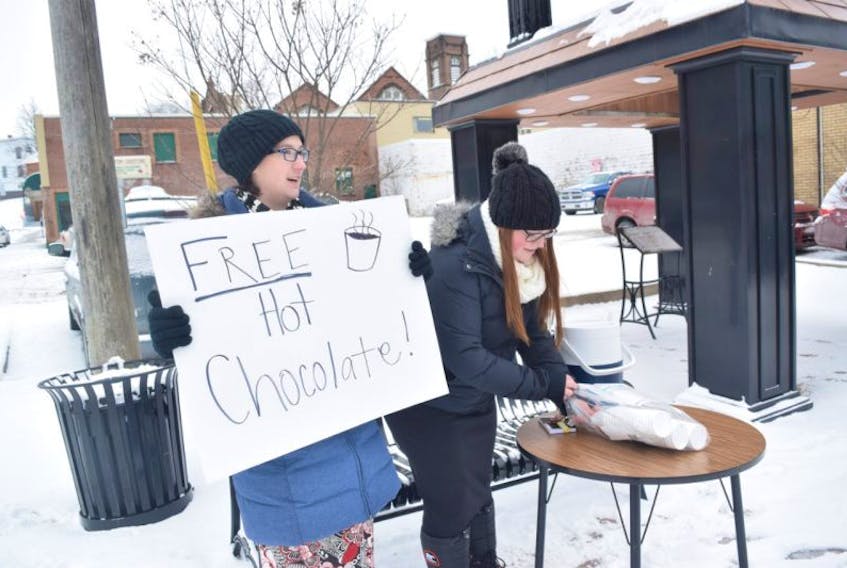 Mallery Moojalsky and Olivia Hotchkiss give away hot chocolate in New Glasgow on Saturday.