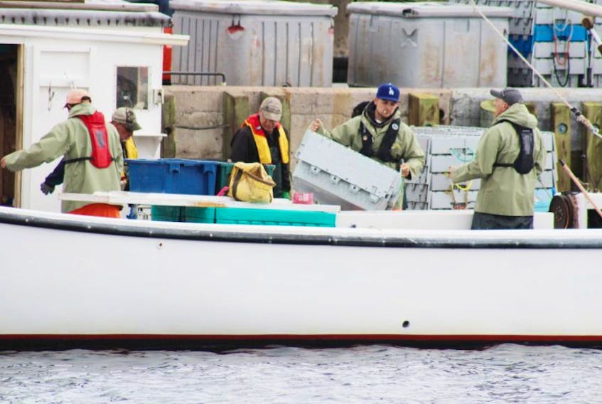 Crewmembers of the White Lady unload lobster at the Caribou wharf they caught Monday.