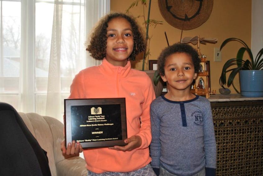 Trinity Dlamini, 11, shown with her brother Khaya, 5, holds the plaque she won for a video she entered in the Delmore Buddy Daye Learning Institute’s African Nova Scotian History Challenge.