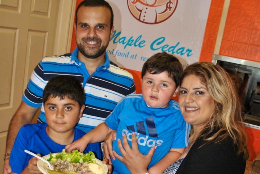 Georgio Haddad holds a shawarma plate at Maple Cedar restaurant, and is pictured with his parents Fred and Patricia and younger brother Chris. The Haddad family recently opened the new business on the east side of New Glasgow.
